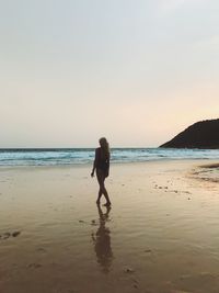 Full length of woman on beach against sky