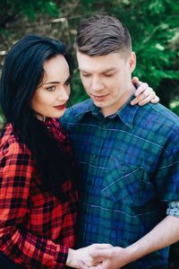 Loving young couple standing in forest