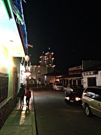 People walking in illuminated city