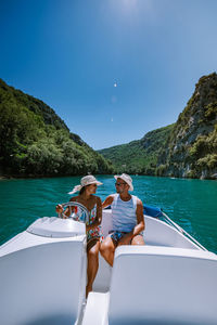 People on boat in sea against sky