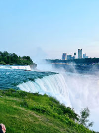  niagara falls showing its power with blue water rushing over the edge under the clear sky 