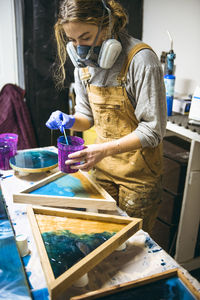 Female resin working in homemade studio