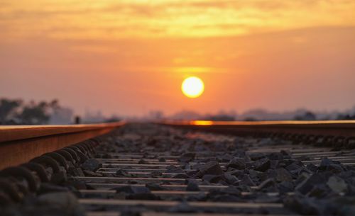 Railroad track against sky during sunset