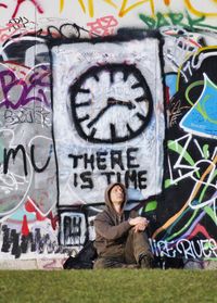 Full length of man sitting on graffiti wall