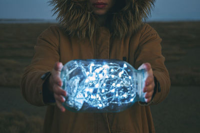 Close-up of a woman holding jar of lights