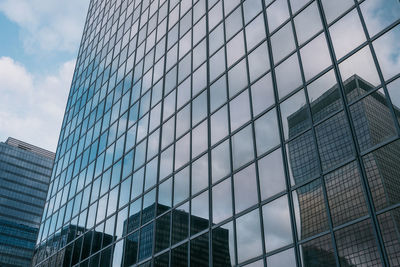 Low angle view of modern glass building against sky