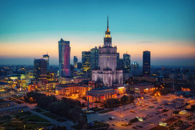 Illuminated buildings in city at dusk