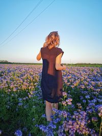 Rear view of woman standing on field