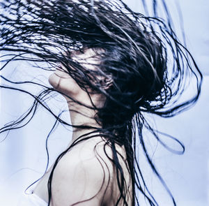 Side view of young woman tossing wet hair in bathroom