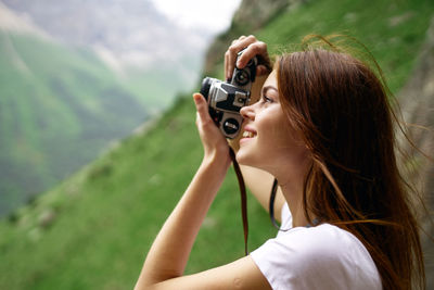 Young woman photographing on field