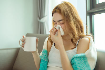 Young woman drinking coffee cup at home