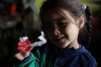 Close-up of smiling girl holding bubble wand