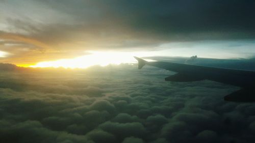 Close-up of airplane wing against sky during sunset