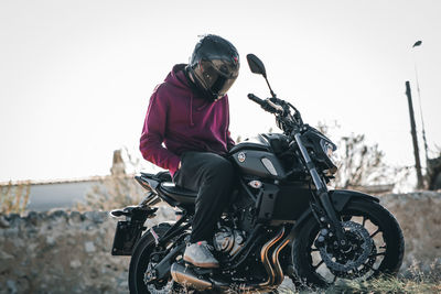 Man riding motorcycle against sky