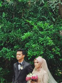 Young couple holding plant in park