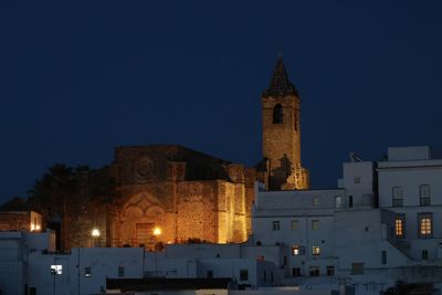 Low angle view of illuminated buildings against clear sky at night