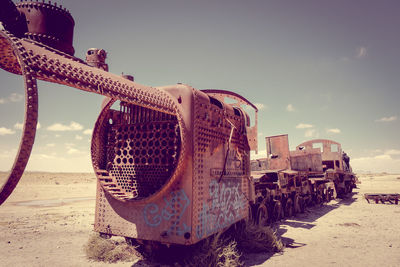 Abandoned truck on beach against sky