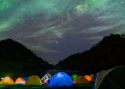 Scenic view of tents against sky at night