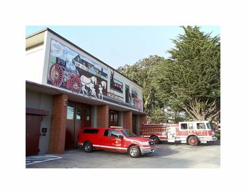 Cars on road by buildings in city