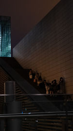 Low angle view of people on building against sky