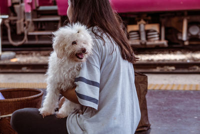 Teenage girl holding dog