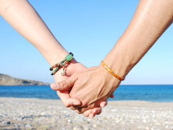 Man hand holding woman hand at beach