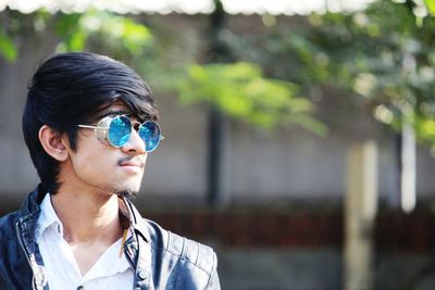 Portrait of young man looking away outdoors