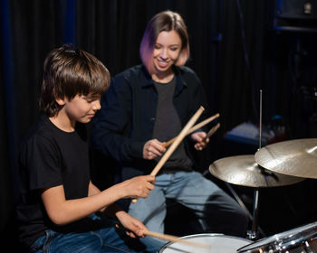 Teacher teaching boy drumming