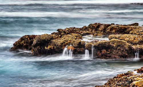 Scenic view of sea against rocks