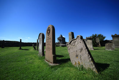 Built structure on field against clear blue sky