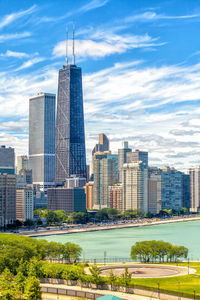 Modern buildings in city against cloudy sky