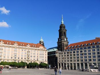 Buildings in city against blue sky