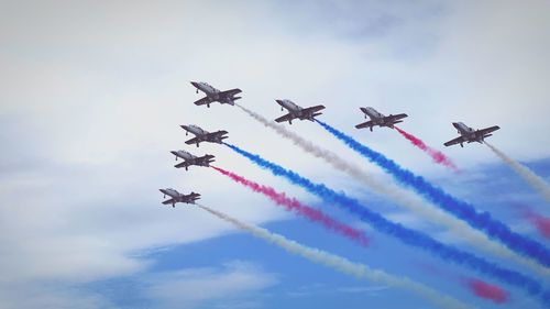 Low angle view of airshow against sky