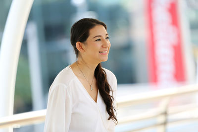 Portrait of a smiling young woman looking away