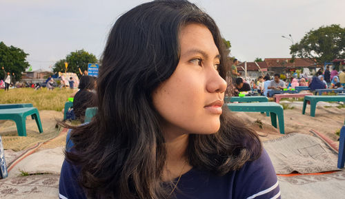 Close-up of young woman looking away at beach