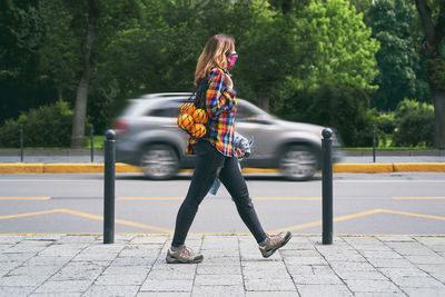 Rear view of woman walking on road