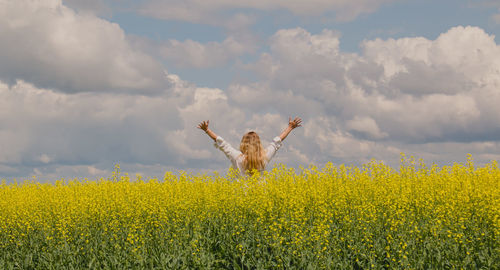 View of woman in field against cloudy sky