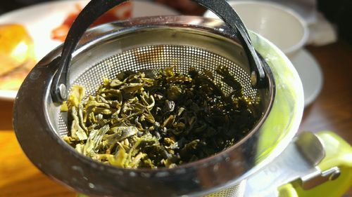 High angle view of green tea in strainer