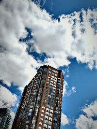 Low angle view of modern building against cloudy sky