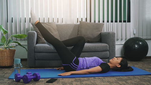 Woman lying on sofa at home