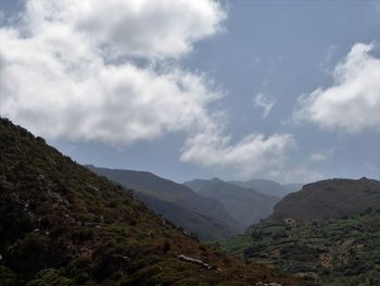 Scenic view of mountains against cloudy sky