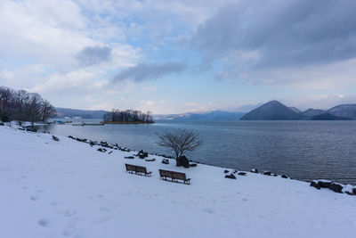 Scenic view of snowcapped mountains by sea against sky