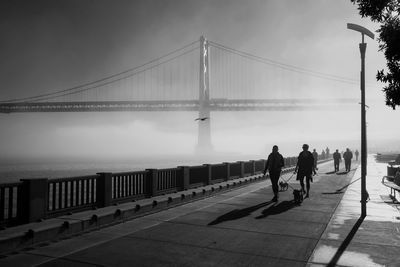 Silhouette of woman walking on bridge