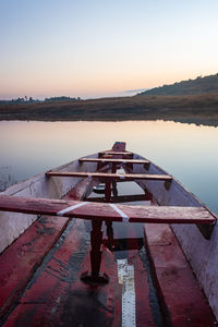 Traditional wood boat at calm lake with dramatic sunrise colorful sky reflection at morning