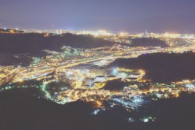 Aerial view of illuminated cityscape against sky at dusk