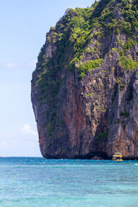 Rock formation in sea against sky