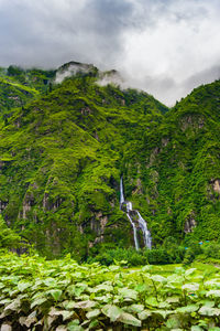 Scenic view of waterfall against sky