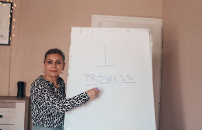 Portrait of woman standing against wall