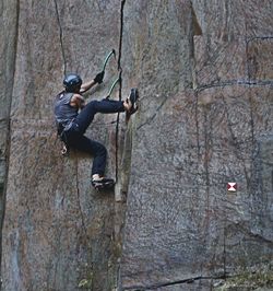 Man with arms outstretched on rock