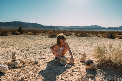 Young girl building with rock in the desert